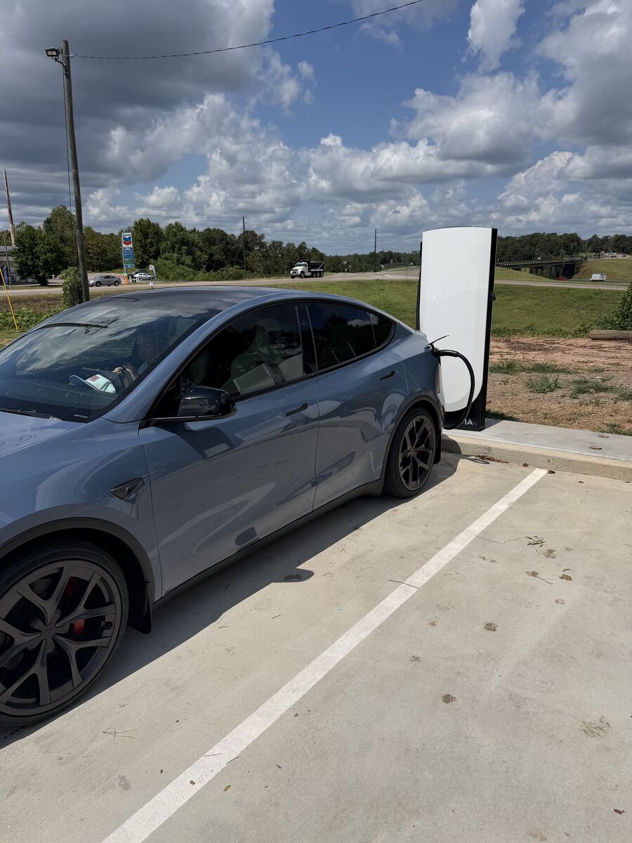 A blue 2026 Tesla Model Y Performance plugged into Supercharger stall 1A at the Prattville Texaco